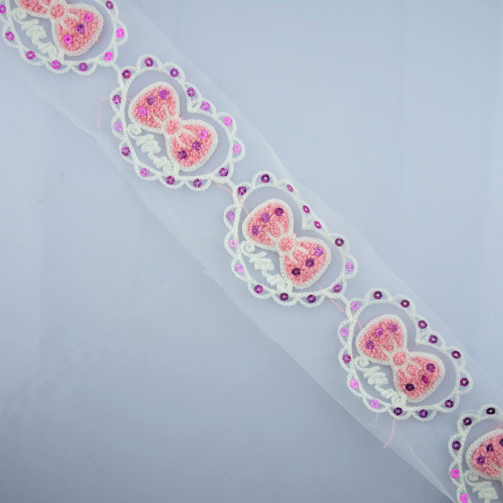 Full metre of pink bow heart design trim displayed.