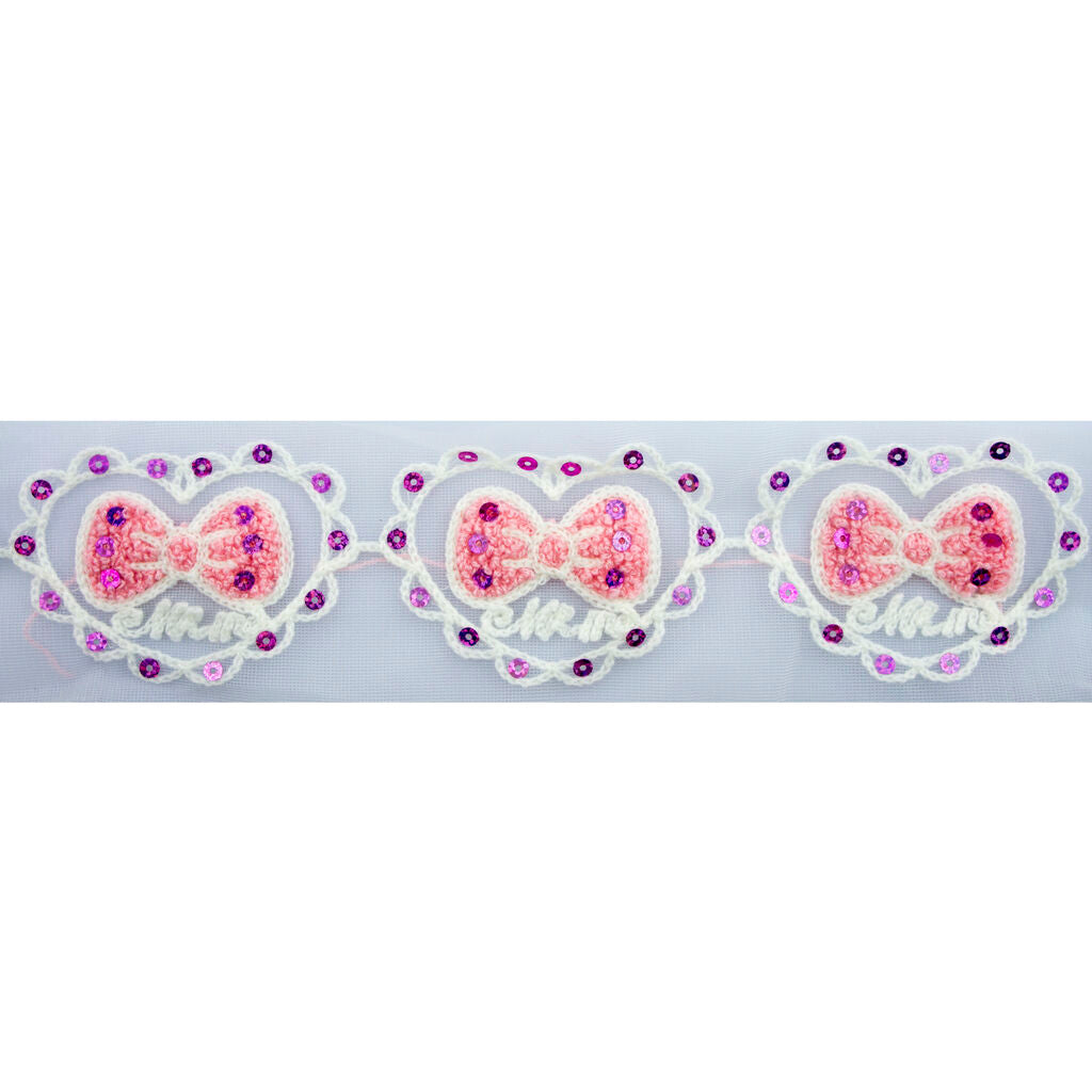 Close-up of pink bow in a heart design fabric trim.