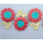 Close-up of knitted flower trim showing pink and blue design