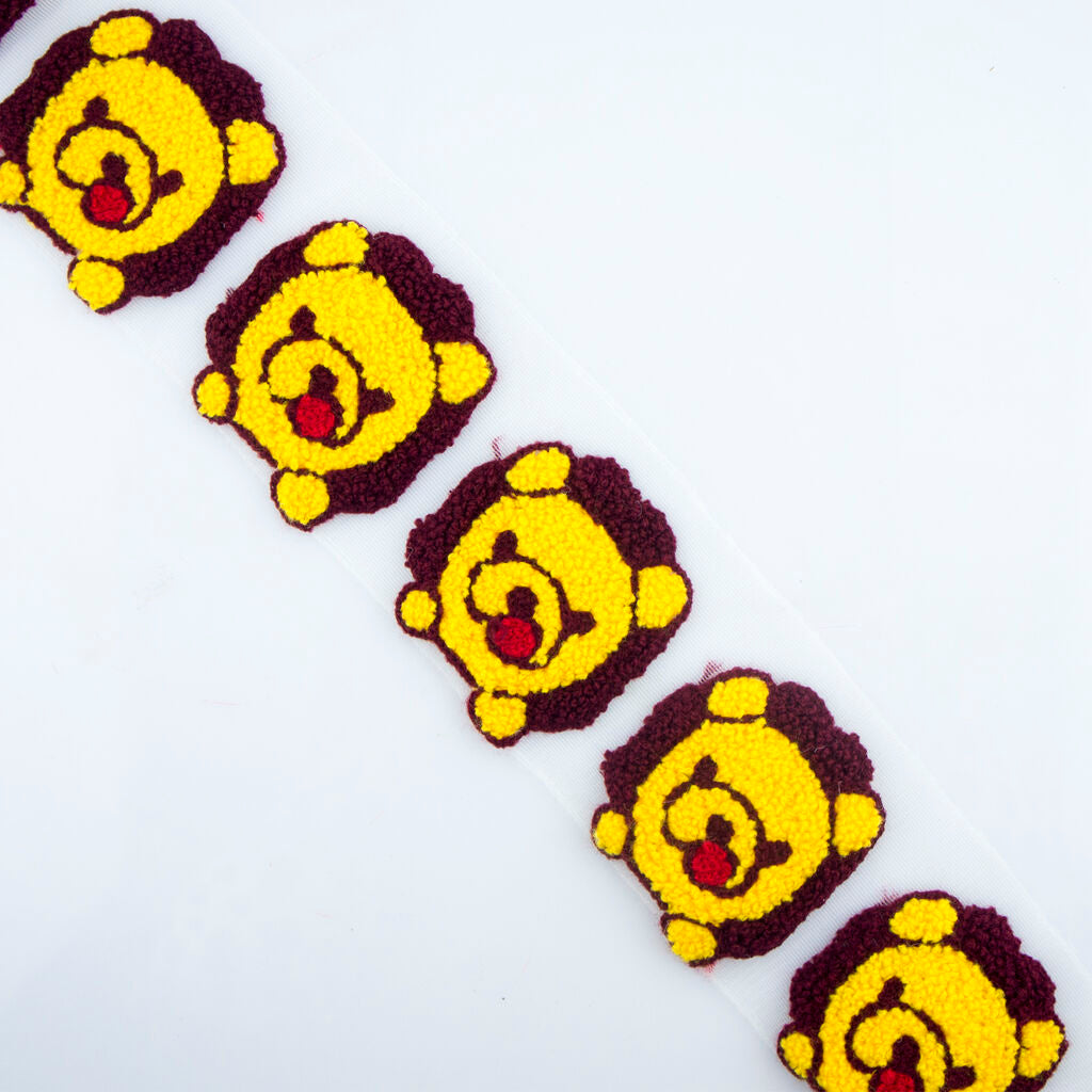 Teddy bear trim displayed on a sewing table with tools.