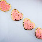 Six pieces of knitted pink heart trims displayed together