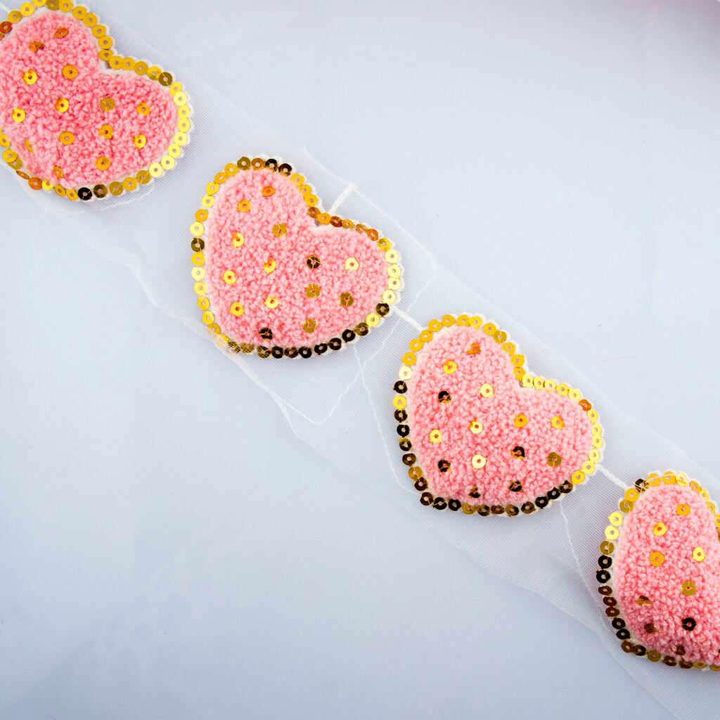 Six pieces of knitted pink heart trims displayed together