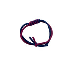 Close-up of a twisting elasticated hair band in navy and burgundy.