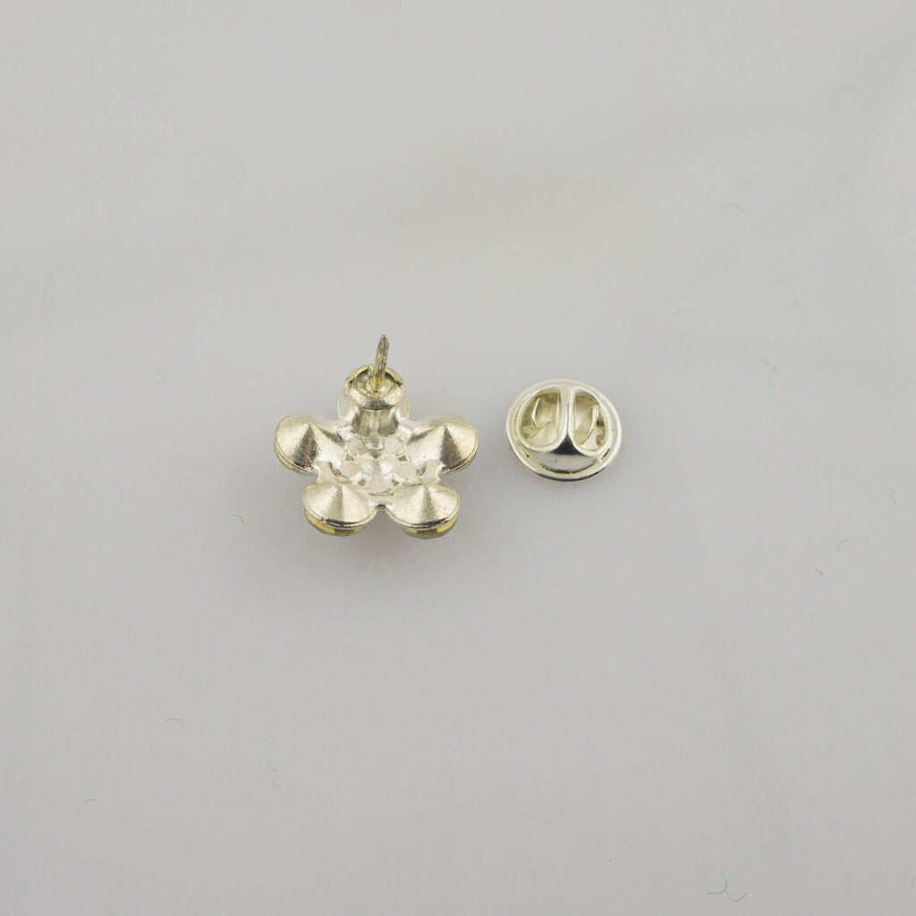 Two white crystal flower brooches displayed together.