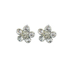 Close-up of a white crystal and silver tone flower brooch.