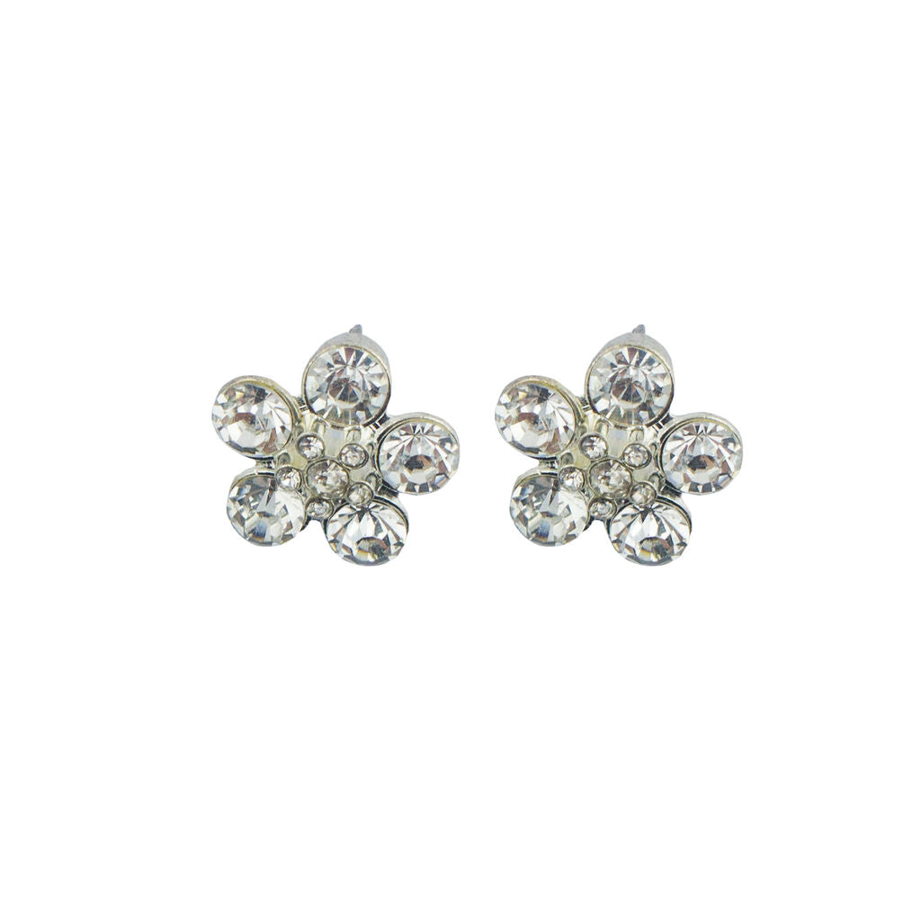 Close-up of a white crystal and silver tone flower brooch.