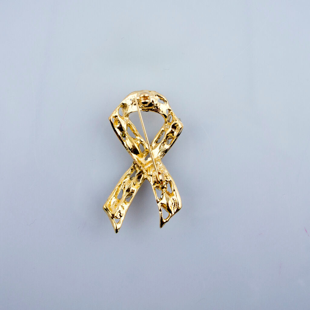 Close-up of the ribbon brooch showcasing clear crystals and gold tone.