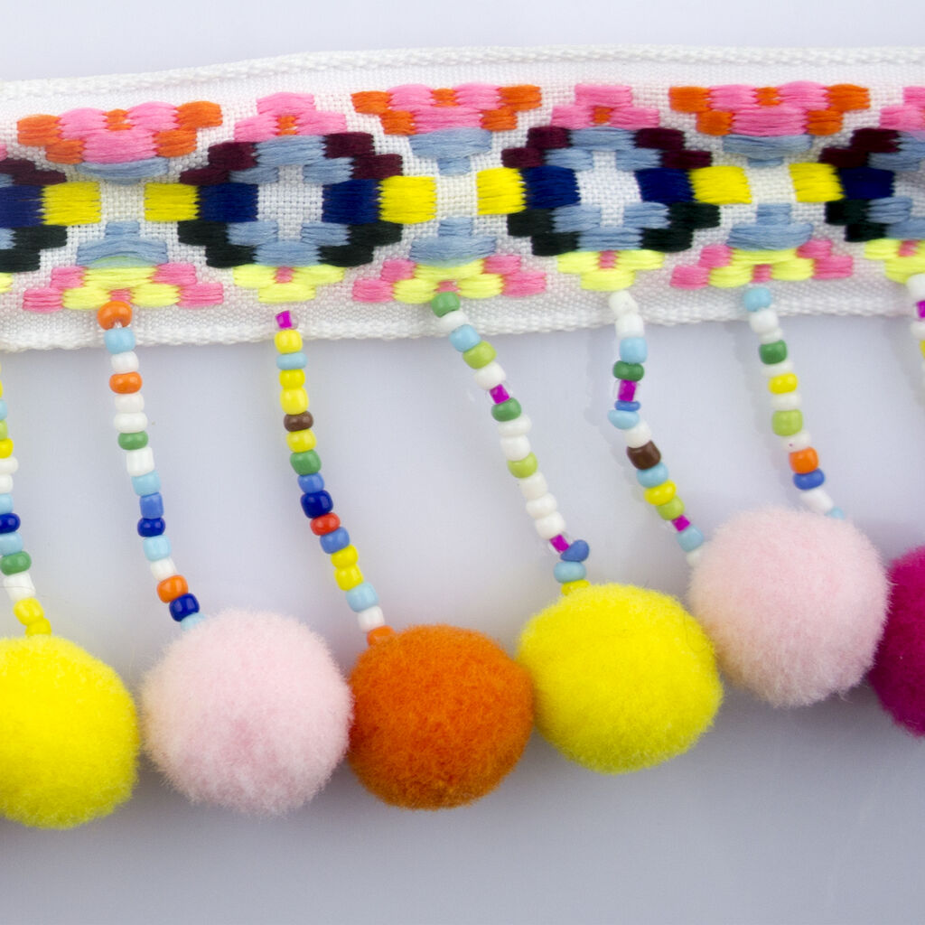 Pom pom trim embellishment rolled out for crafting use.