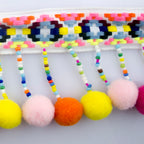 Pom pom trim embellishment rolled out for crafting use.