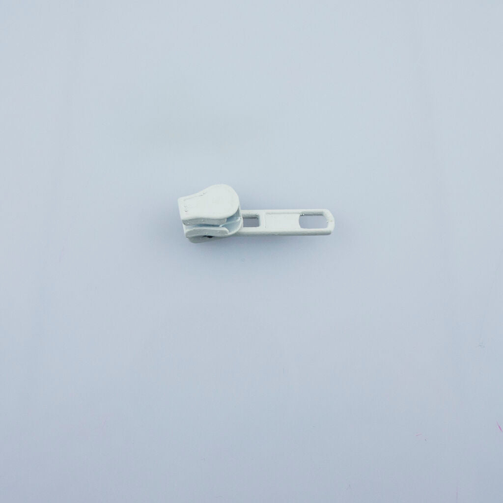 Close-up of a white automatic head slider zip pull for sewing.