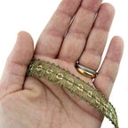 Close-up of 15 mm wide antique gold metallic trim for sewing projects.