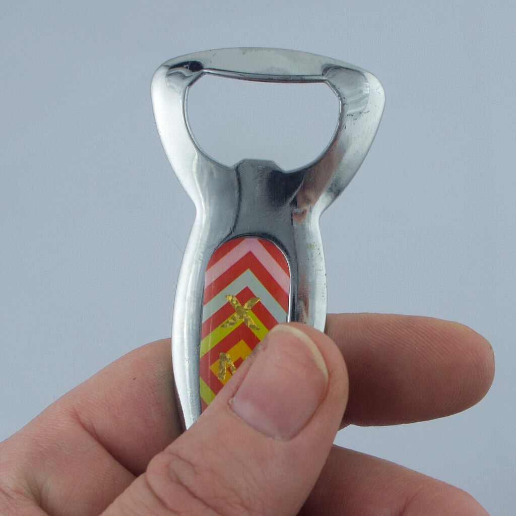 Close-up of a colourful motif on a stainless steel bottle opener.