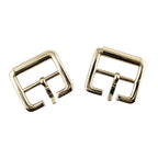 Close-up of a light shiny gold square metal buckle showing detail.