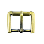Close-up of a vintage gold square metal buckle on a fabric background.