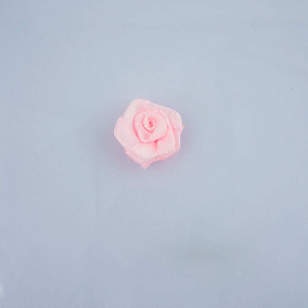 Close-up of 21 mm baby pink rose ribbon trims in a pack.