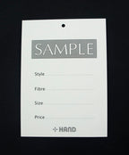 Close-up of garment sample card showing style, fibre, size, and price fields.