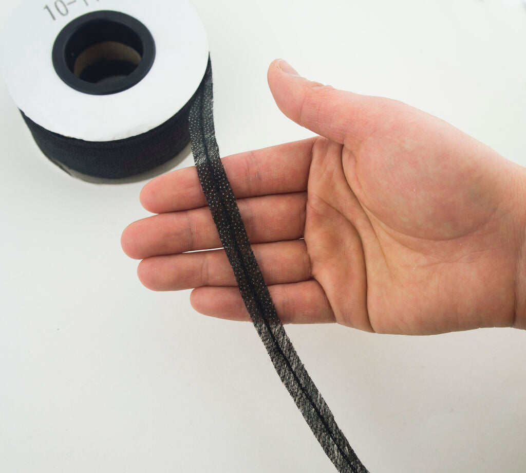 Spool of black bias tape showing its 10 mm width.