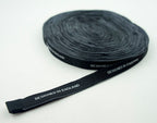 Close-up of black woven label with white text.