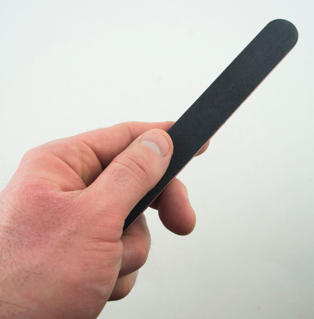 Close-up of a nail file showing its texture and size.