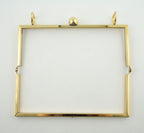 Flat lay of the gold tone shoulder bag frame measuring 175 x 75 mm