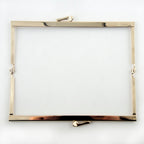 Close-up of the kiss clasp on the gold tone purse frame.