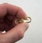 Gold tone metal snap hook clasp attached to a keyring.