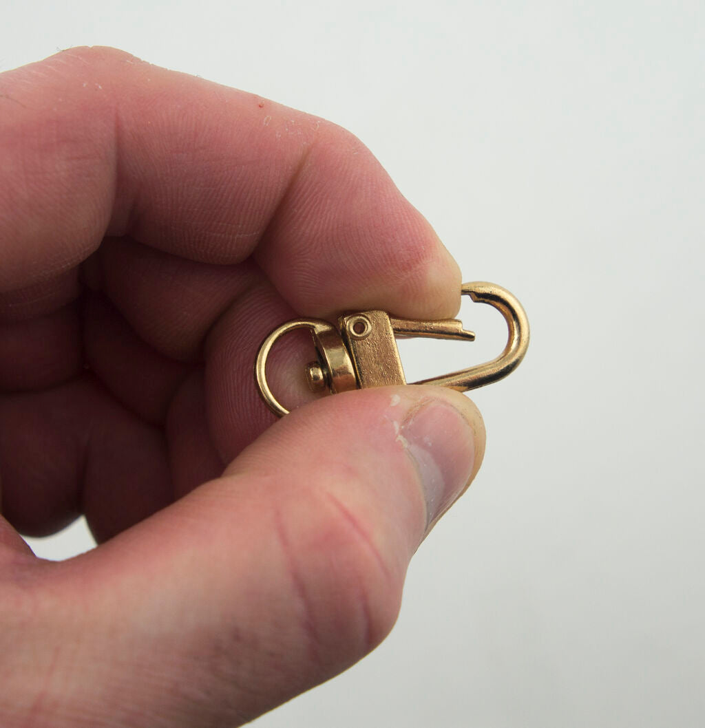 Gold tone metal snap hook clasp attached to a keyring.
