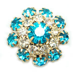 Display of marine blue crystal buttons on a fabric background.