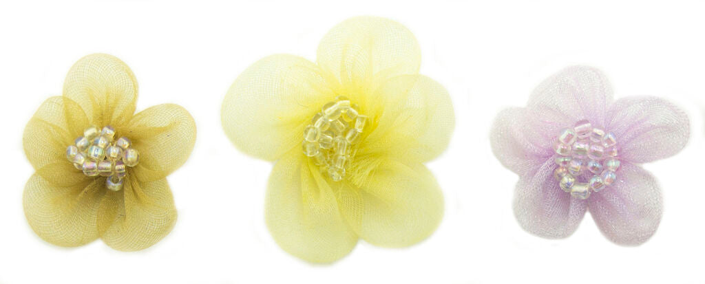 Variety of pink organza flower trims on a crafting table