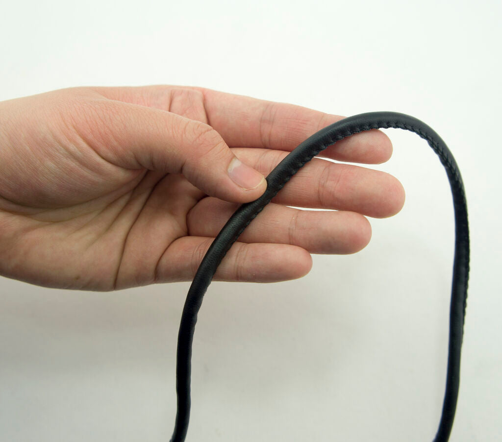 Close-up of 5 mm wide black PU trim piping for sewing projects.