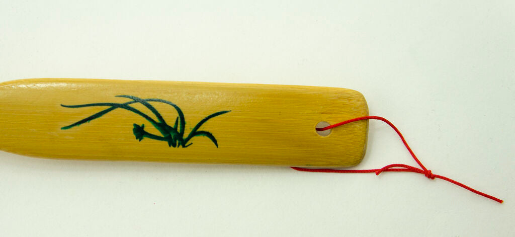 Back scratcher held in hand to demonstrate its length and use