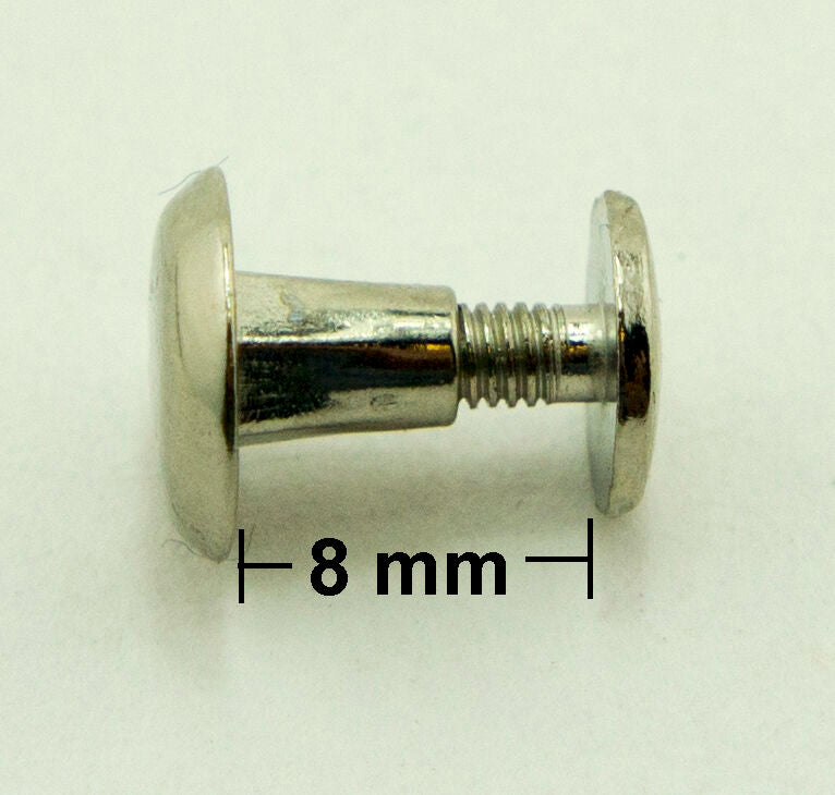 Binding screws in use, securing papers and fabric samples together.