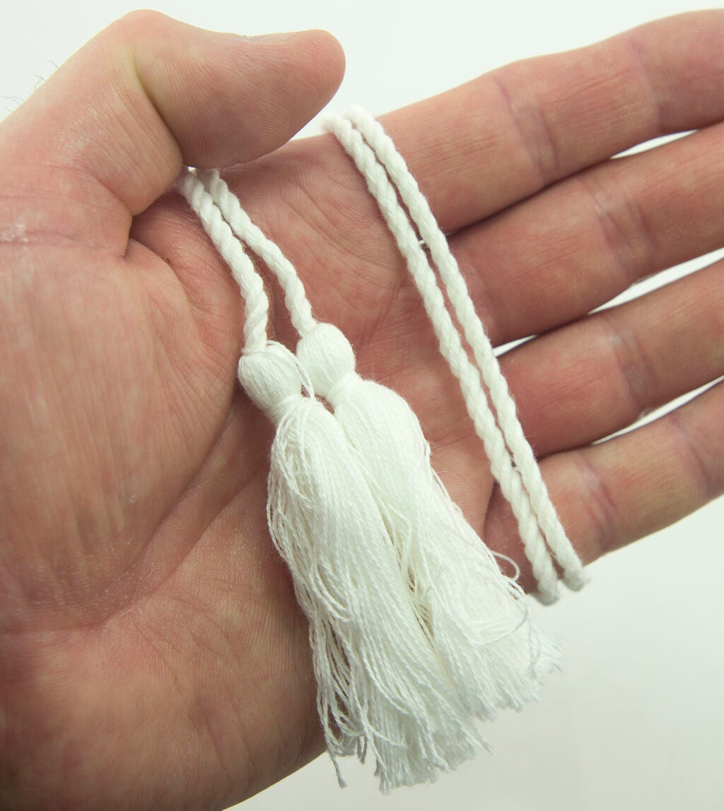 Close-up of white cotton tassels showcasing their double end design.