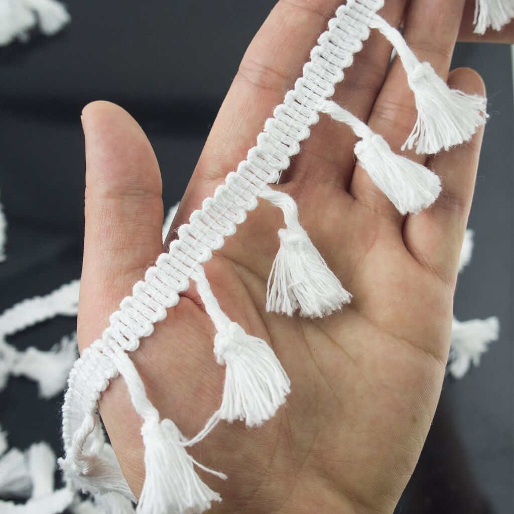 Roll of white cotton tassel trim with tassels visible.