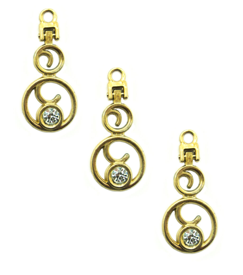 Gold tone and white crystal zip pull pendant on a fabric background.