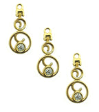 Gold tone and white crystal zip pull pendant on a fabric background.