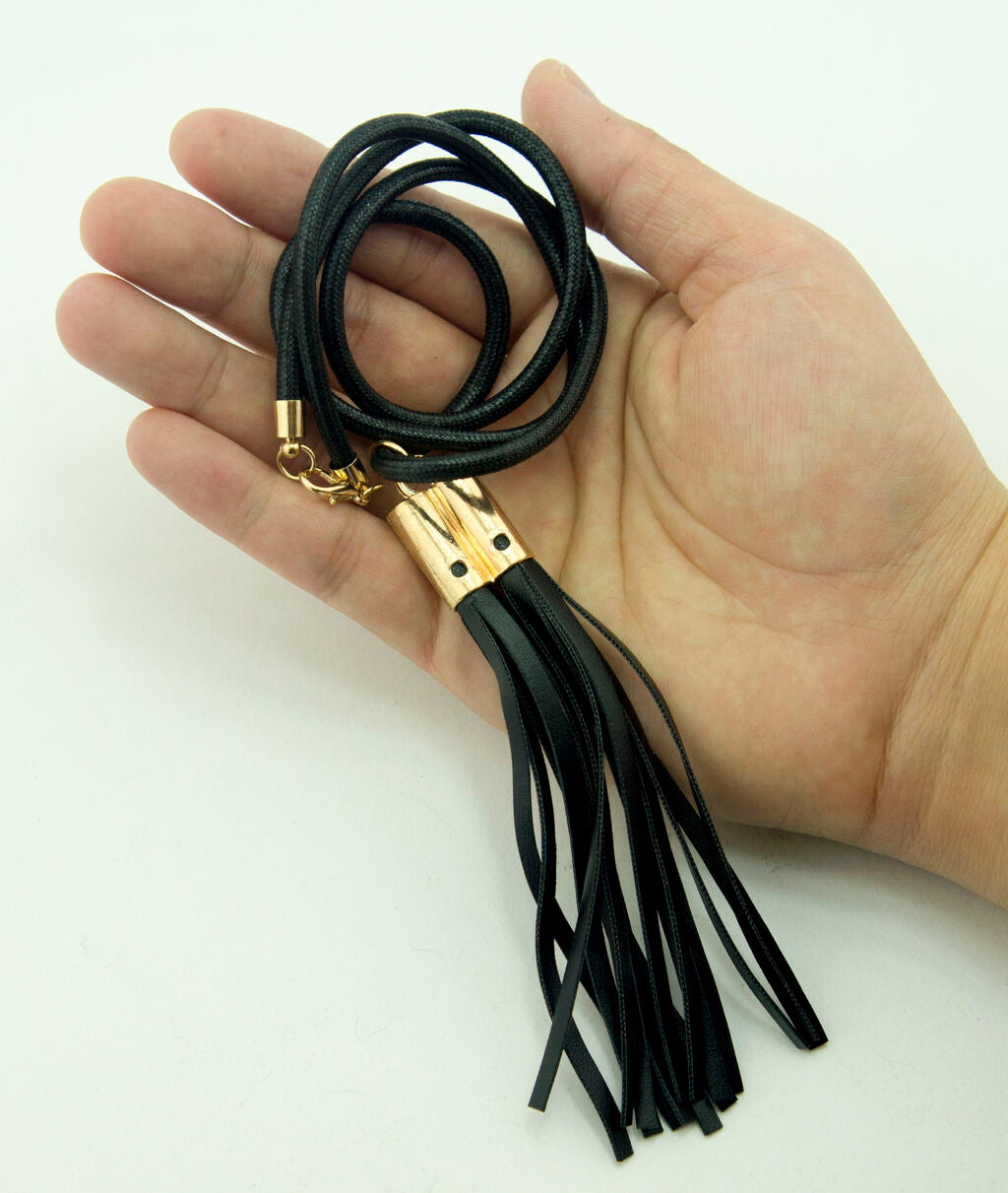 Close-up of the black leatherette tassel and lobster claw fastener.
