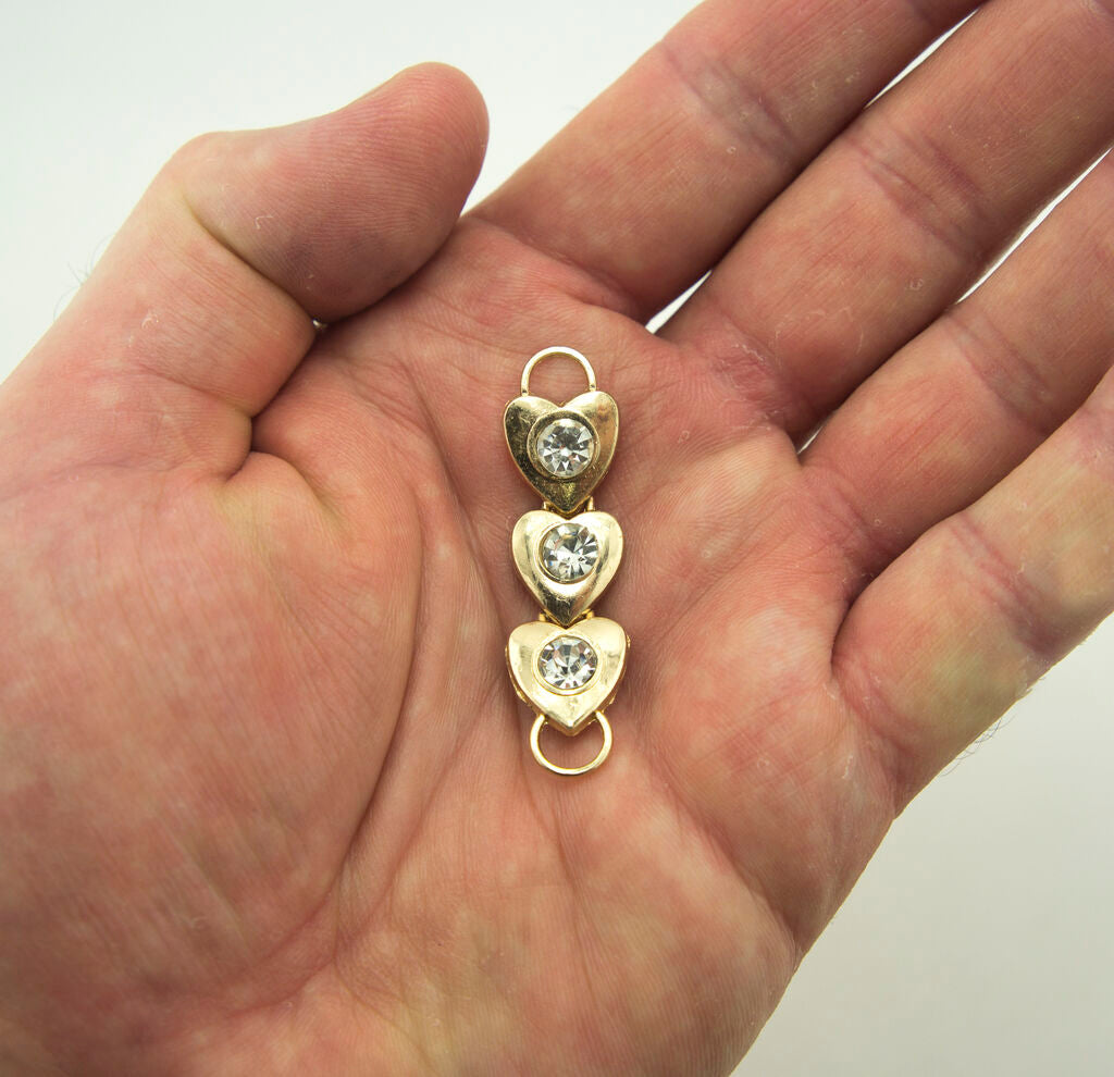 Close-up of gold tone hearts and crystals for crafting