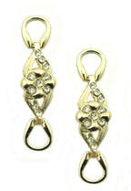Two feminine flower embellishments in gold tone and white crystals.