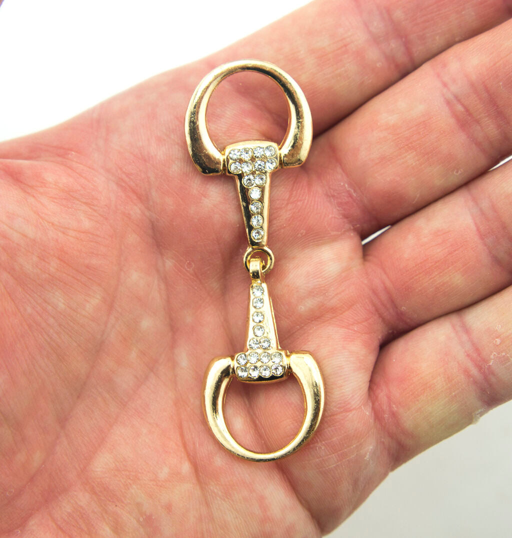 Close-up of the elegant gold tone and white crystal buckle.