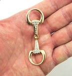 Close-up of the elegant gold tone and white crystal buckle.