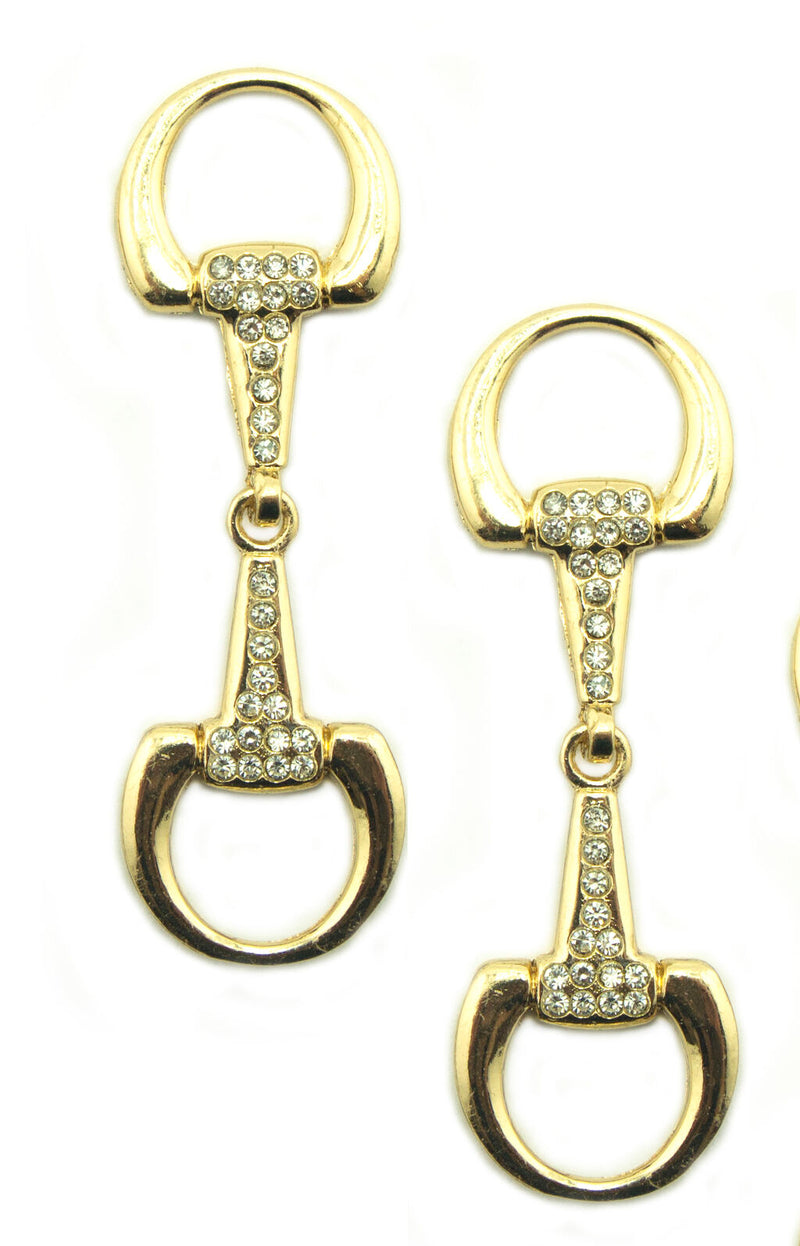 Gold tone equestrian buckle with white crystals on display.