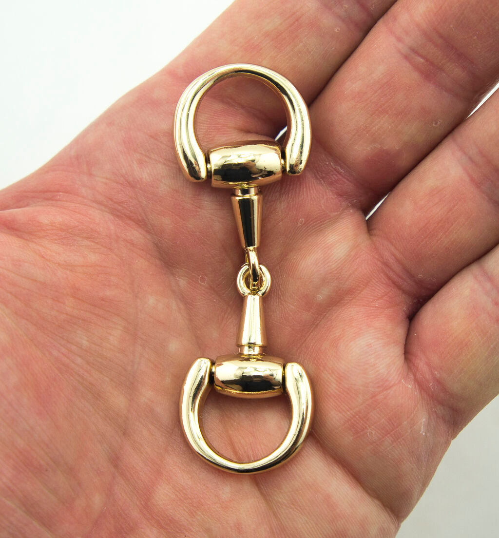 Close-up of a polished gold equestrian buckle showing detail.