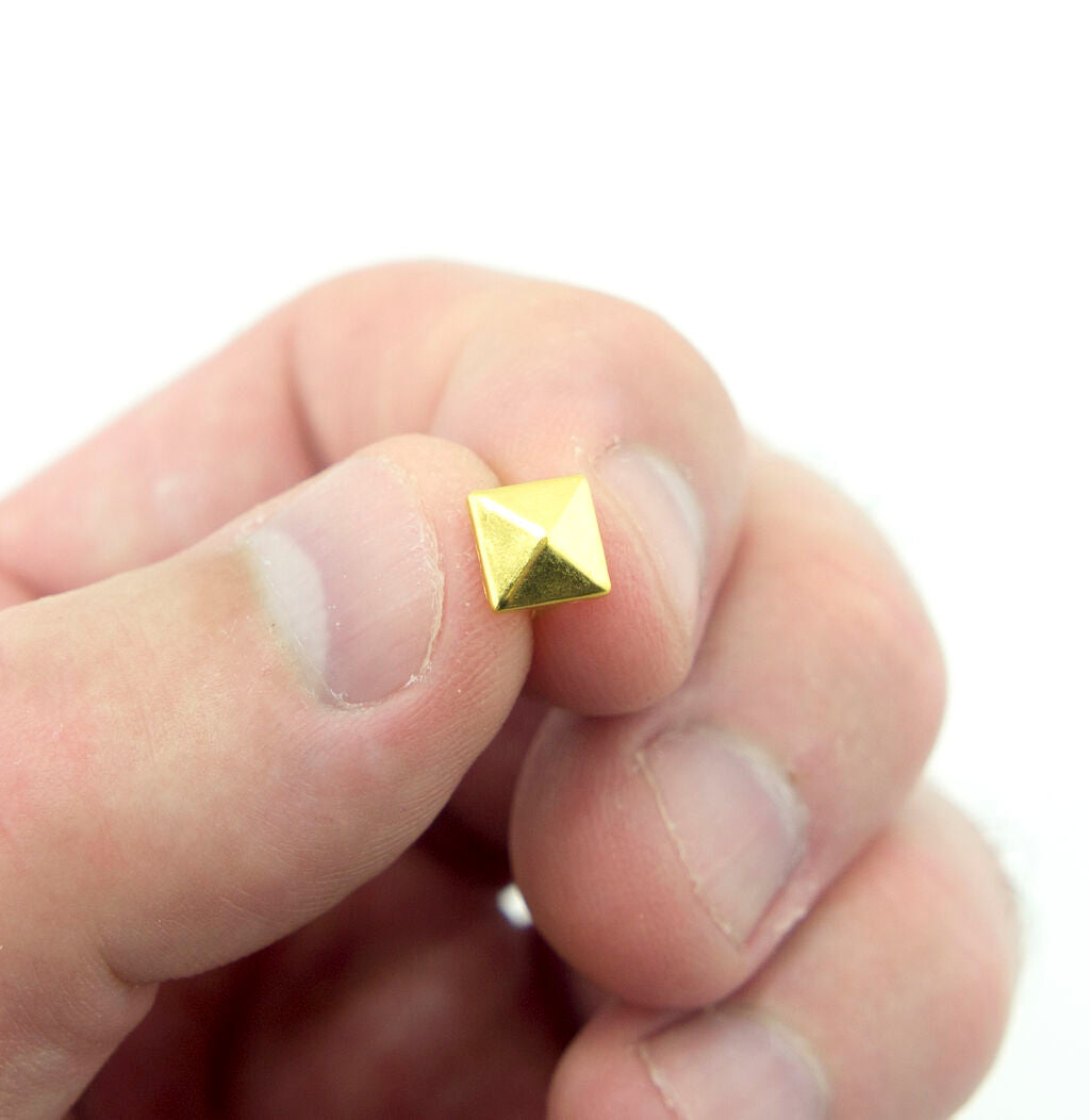 Close-up of a 7 mm gold tone pyramid stud