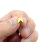 Close-up of a 7 mm gold tone pyramid stud