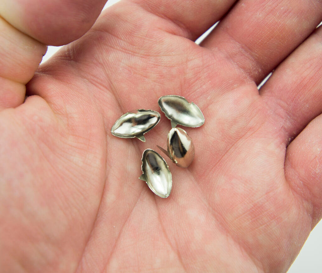 Close-up of oval silver tone metal studs, size 6 x 14 mm