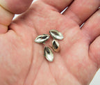 Close-up of oval silver tone metal studs, size 6 x 14 mm