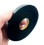 Close-up of 10mm black fusible bias tape on a white background.