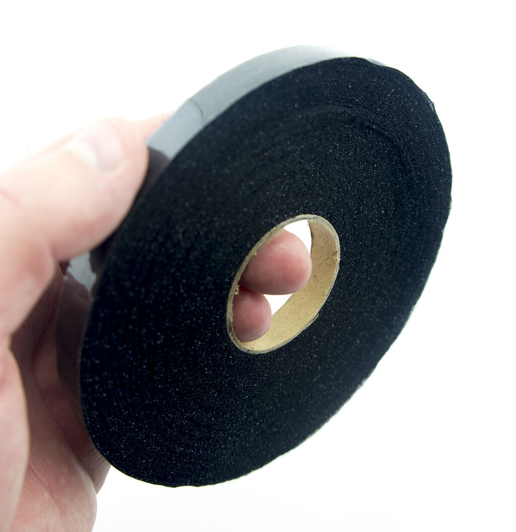 Close-up of 10mm black fusible bias tape on a white background.