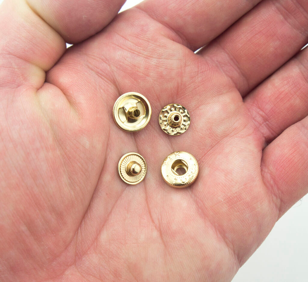Pack of 20 light brass tone press stud buttons arranged neatly.